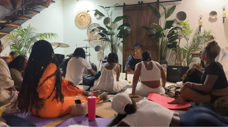 Joy Soul, a sound therapist, leads a sound bowl mediation for a crowded group of participants in an intimate setting.