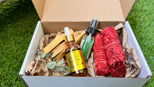 Worthy Spiritual Cleansing Box by Joy+Soul with wellness products including yoni oil, palo santo, mist, and red dragons blood sage on a grass background